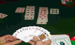 des cartes dans une main et sur une table, une partie de bridge