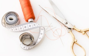 les outils de couture, mètre ruban, aiguilles, bobine de fil une paire de ciseau