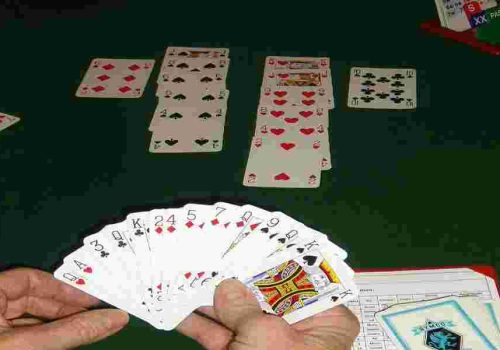 des cartes dans une main et sur une table, une partie de bridge